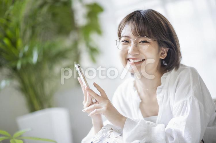 一個戴眼鏡的女人拿著智能手機微笑, 女子, 日本人, 智能手机, JPG